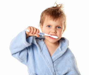 Little cute boy brushing his teeth on a white background