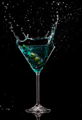 Martini drink with splash, isolated on black background