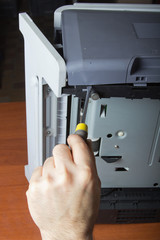 men's hands repairing laser printer