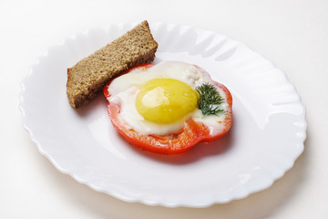 Fried egg on sweet pepper and piece of bread