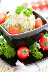 rice with tomatoes in a black bowl