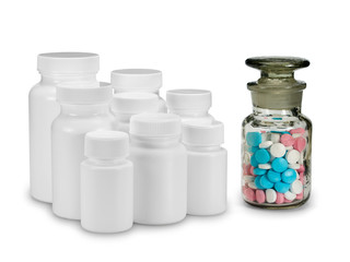 Group of plastic small bottles against a glass vial with pills.