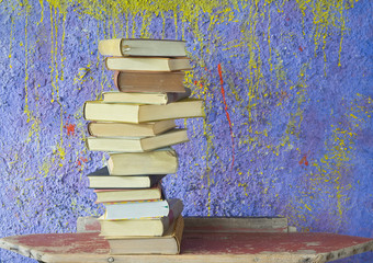 stack of vintage books, against purple background