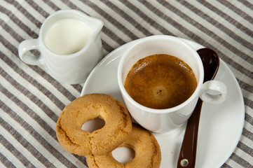 tazzina di caffè, biscotti e un bricchetto di latte