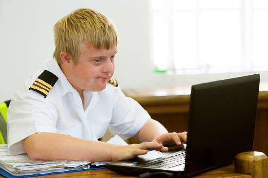 Young handicapped pilot working with laptop.