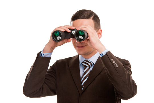 Closeup of a young business man looking through binocular isolat