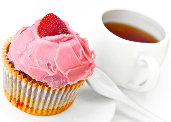 Fruitcake with a strawberry and a cup of tea