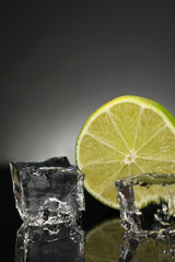 Ice cubes with lime on black background