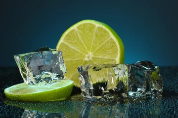 Foto auf Acrylglas Eiswürfel mit Limette auf dunkelblauem Hintergrund © Africa Studio