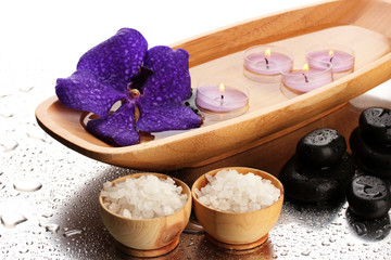 Obraz na płótnie Canvas Spa stones and wooden bowl with candles and purple flower,
