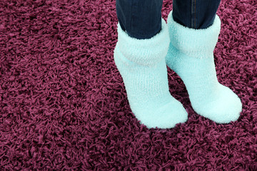 Female legs in colorful socks on color carpet background