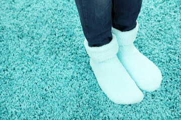 Female legs in colorful socks on color carpet background