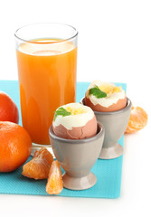 Light breakfast with boiled eggs and glass of juice, isolated