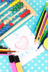 Toy abacus, note paper, pencils on bright background