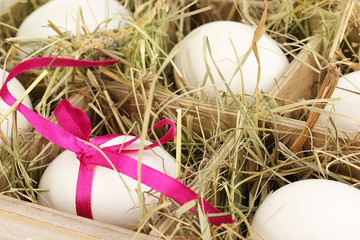 Decorative Easter eggs in wooden basket close up