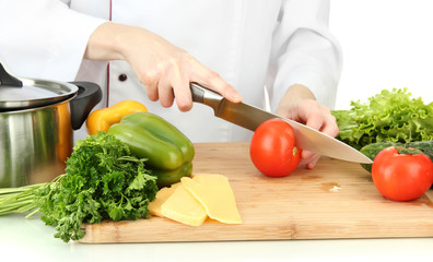 Female hands cutting vegetables, isolated on white