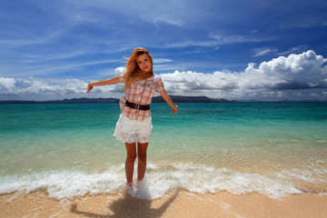 Fototapeta premium 南国沖縄の美しいビーチで寛ぐ笑顔の女性