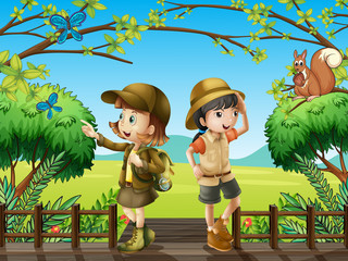 Une fille et un garçon au pont en bois