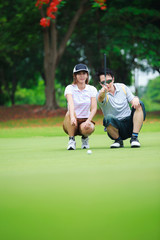 Obraz premium Professional teaching young woman golfer
