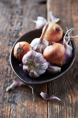 Rustic garlic bulbs and onions on wooden background