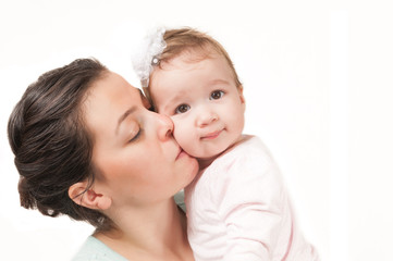 Isolated mother kissing her baby girl on white background
