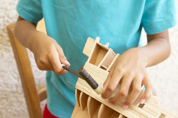 Enfant fabriquant un modèle réduit de bateau