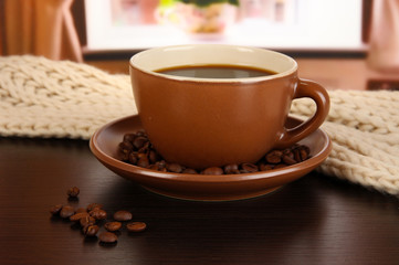 cup of coffee with scarf on table in room