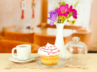 Cupcake on saucer with glass cover, on bright background