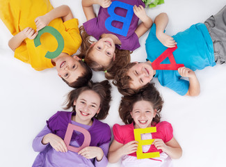Happy school kids with colorful alphabet letters