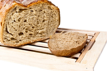 Fresh loaf of bread on cutting board white background