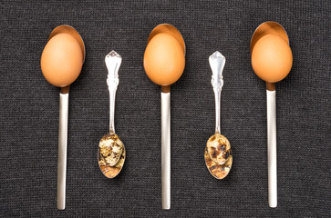 Chicken and quail eggs in spoons