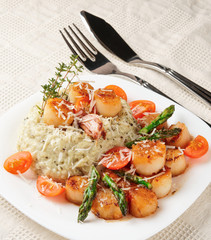 Risotto with pan seared sea scallops on table