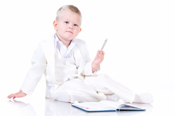 Cute baby in a white business suit with a diary