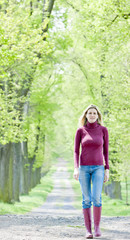 Obraz premium woman wearing rubber boots in spring alley