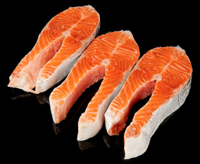 Three raw fresh salmon steaks isolated on black
