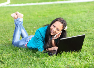 young woman lying down using a laptop