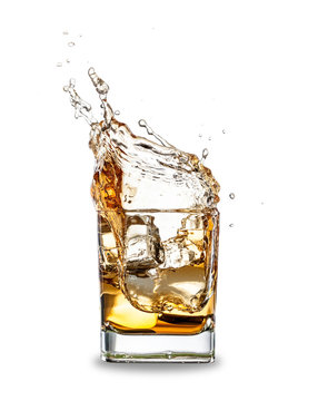 Whiskey splashing out of glass, isolated on white background