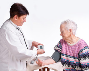 Elderly doctor and patient. Measuring pressure.