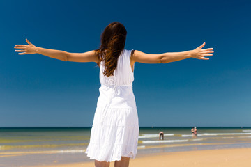 Fototapeta na wymiar Attractive woman standing in the sun on beach
