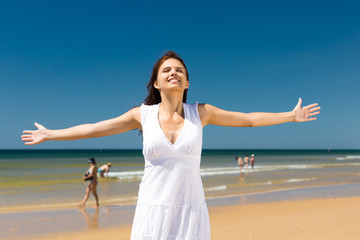 Fototapeta na wymiar Atrakcyjna kobieta, stojąca w słońcu na plaży