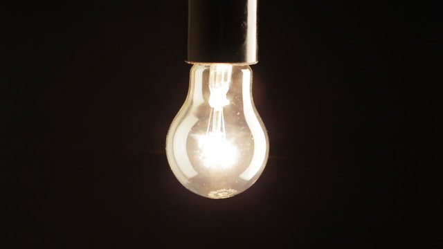 Real light bulb turning on, back lit, close-up, HD