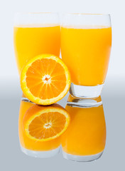 A glass of orange juice on a mirror