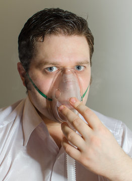 Portrait of young man with inhalator mask on the face