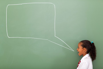 elementary schoolgirl with speech bubble drawn on chalkboard