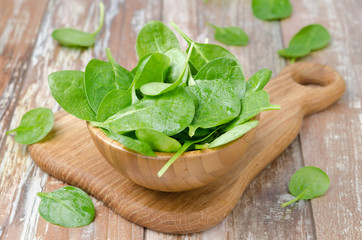 Fresh spinach in a wooden bowl, horizontal