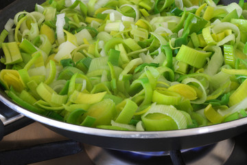 Sliced leek in frying pan on gas cooker