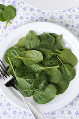 Baby spinach salad in a white plate.