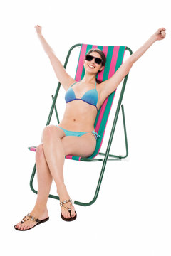 Young bikini woman relaxing on deckchair
