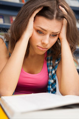 Stressed female student in a university library