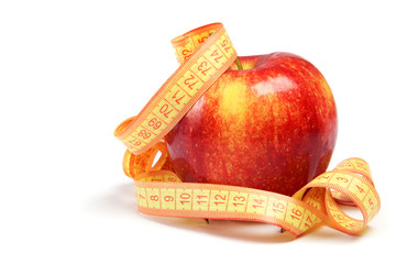 Red apple and measuring tape on a white background.